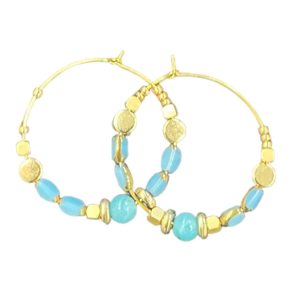 Elevate your style with the Azure Breeze earrings by Maggie Deall. Handcrafted with sky-blue beads and golden accents, perfect for any occasion.